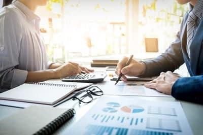 deux comptables qui discutent en analysant des graphiques
